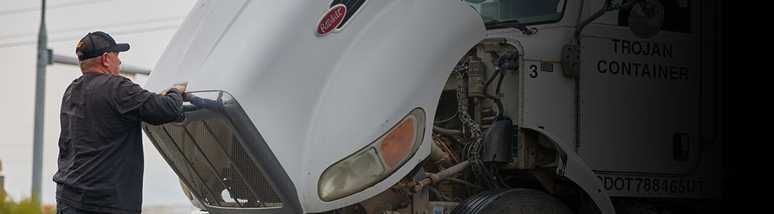 truck driver or mechanic checking under the hood