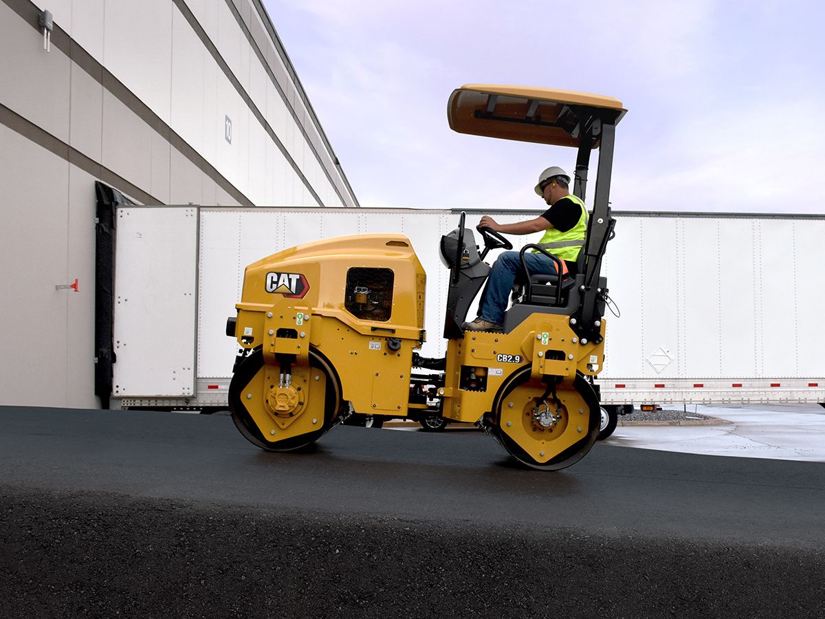 CB2.9 tandem vibratory roller compacting asphalt in a parking lot.