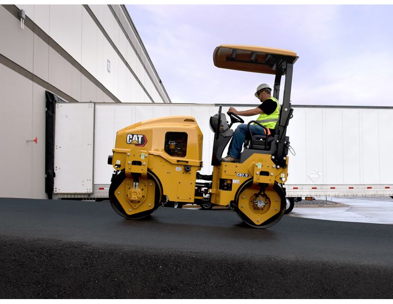 CB2.9 tandem vibratory roller compacting asphalt in a parking lot.