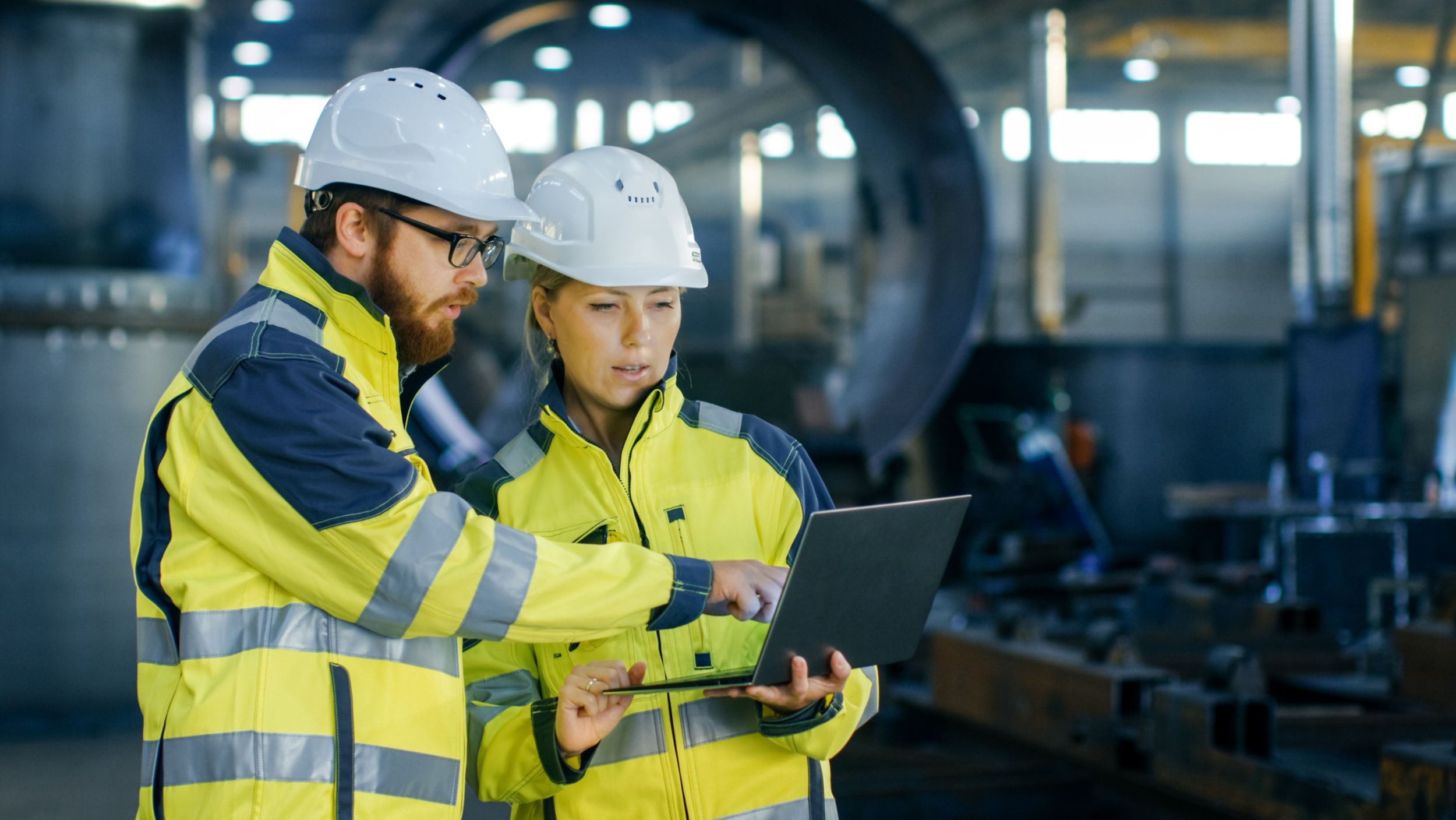 Two manufacturing employees working at jobsite