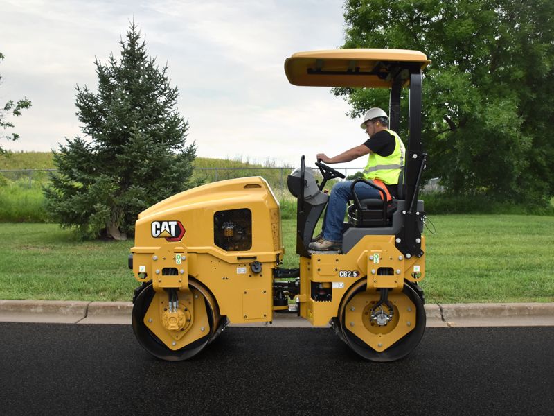 CB2.5 tandem vibratory roller compacting asphalt in a parking lot.