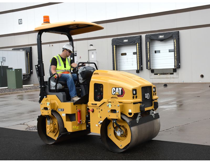 CB2.7 tandem vibratory roller compacting asphalt in a parking lot.