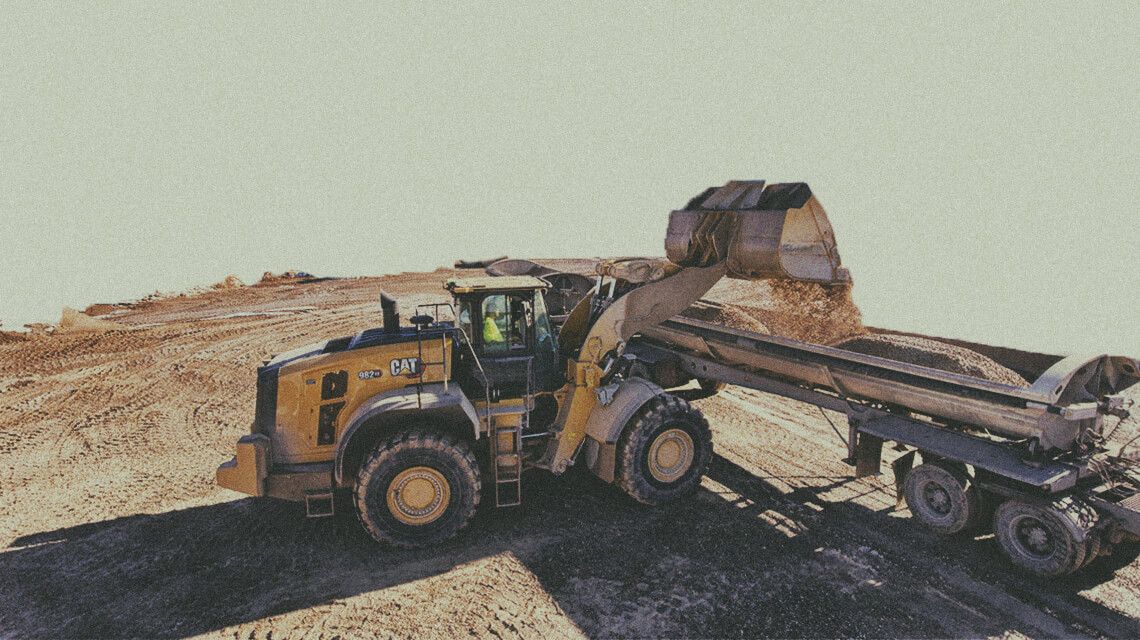 wheel loader dumping material into truck