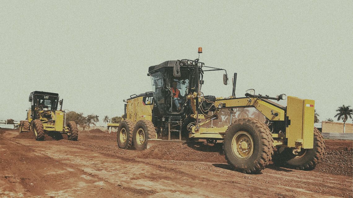 Two motor graders pushing dirt on jobsite