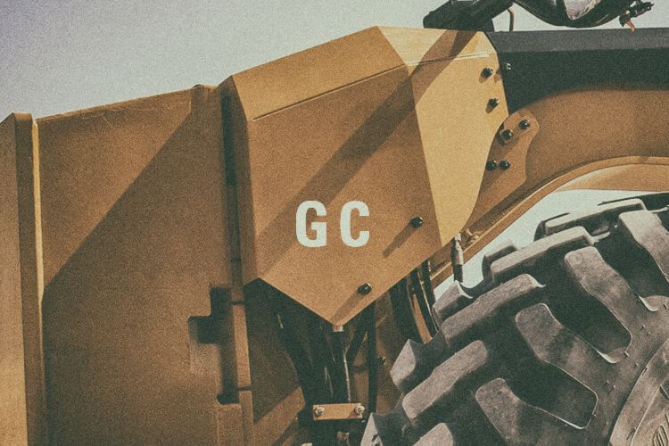Closeup of motor grader with "GC" graphic