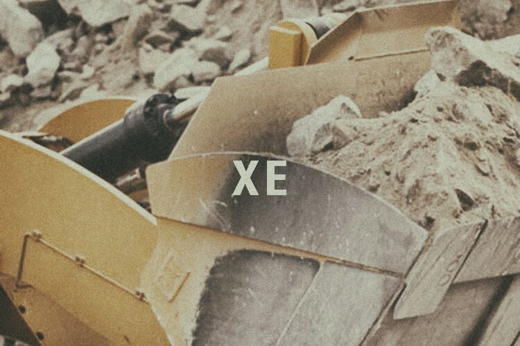 Closeup of wheel loader bucket with "XE" graphic