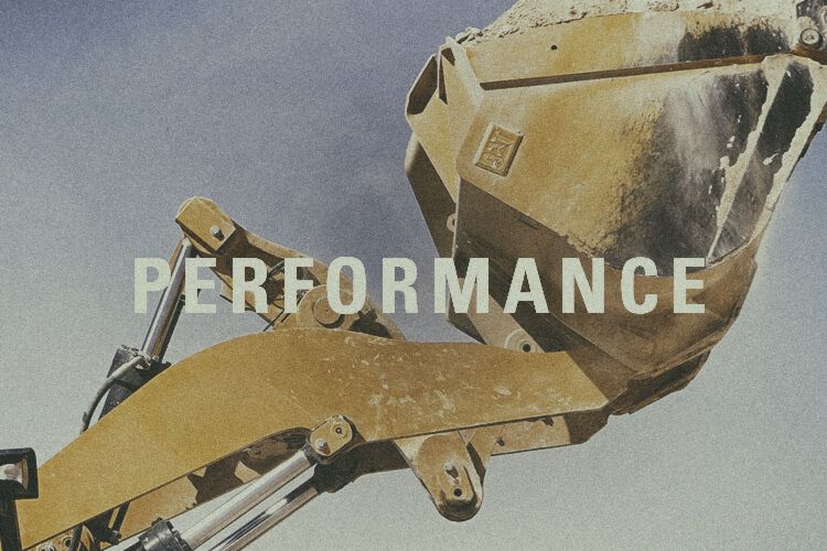 Closeup of wheel loader bucket with "Performance" graphic