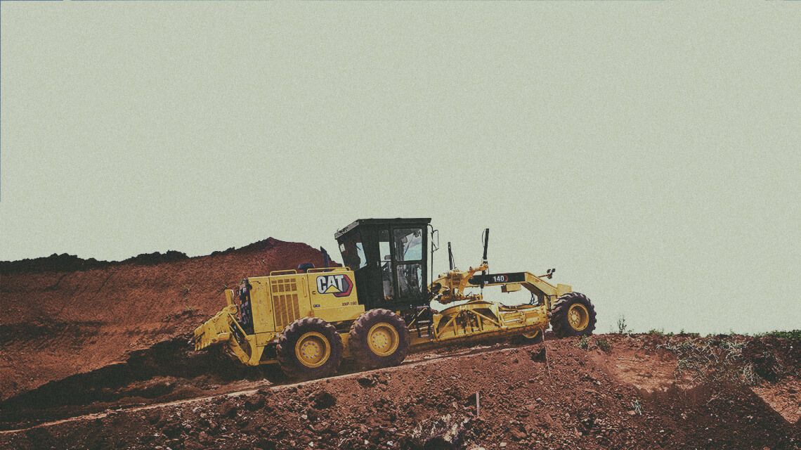 Motor grader pushing dirt on jobsite