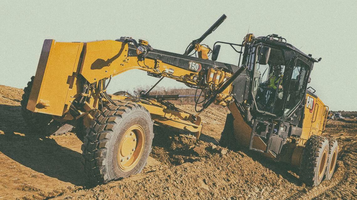 Motor grader pushing dirt on jobsite