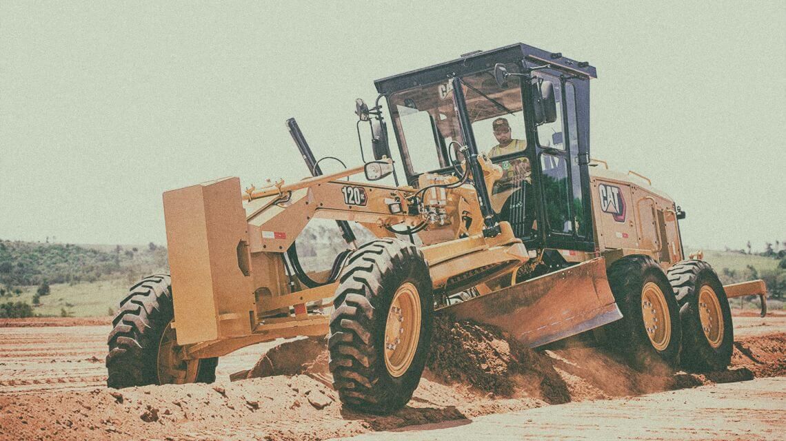 Motor grader pushing dirt on jobsite