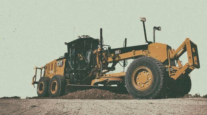 Motor grader tilling dirt