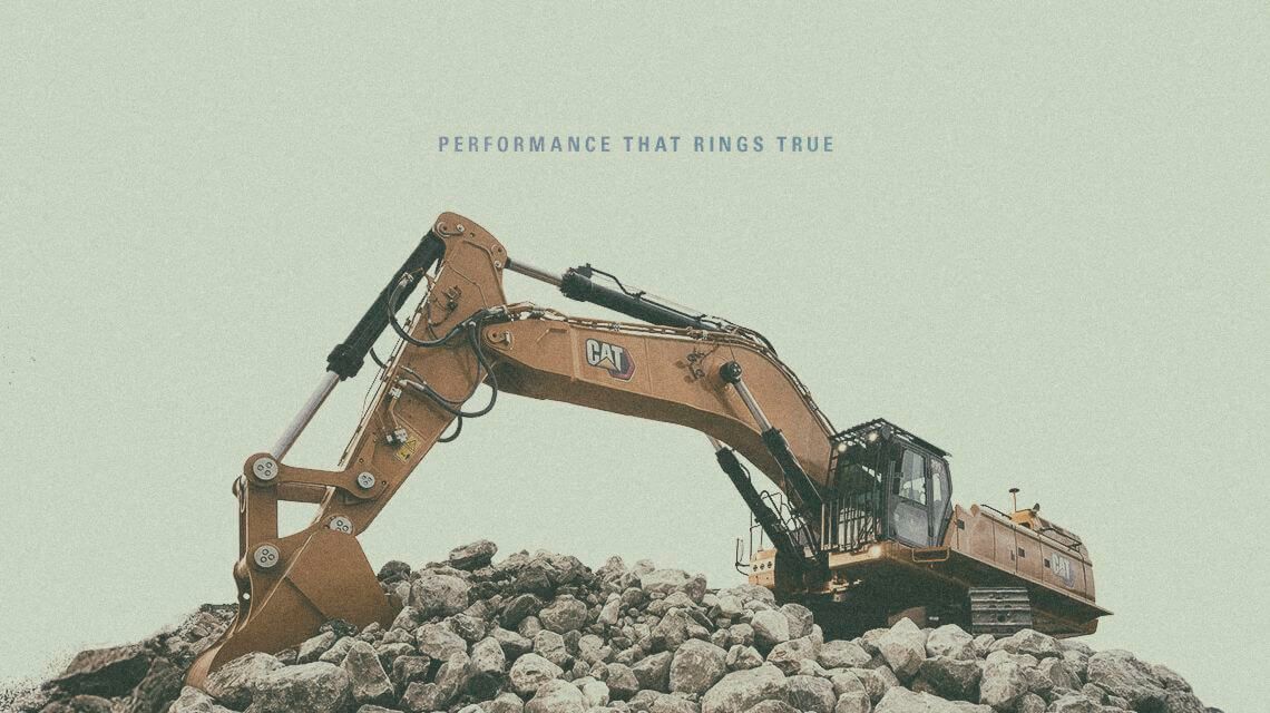 Cat® Excavator digging into large stones with "Performance That Rings True" text graphic