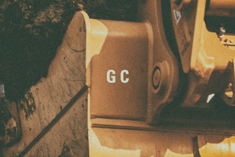 Closeup of excavator bucket with "GC" graphic