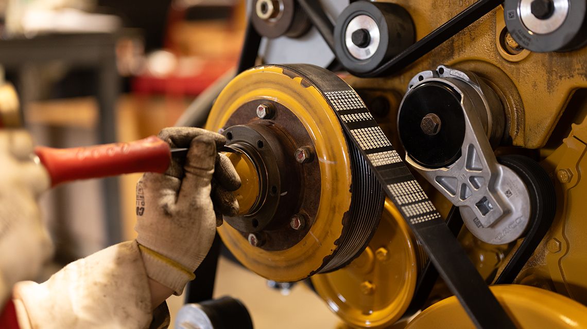 A Cat dealer technician works on a piece of equipment. 