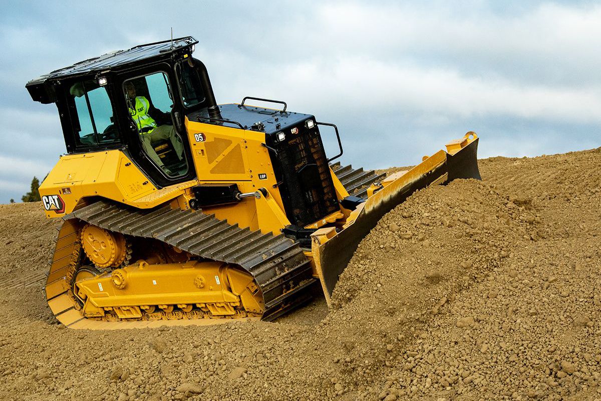 Trator D5 empurrando pilha de terra