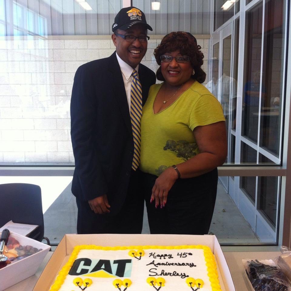 Woman and man standing behind a cake
