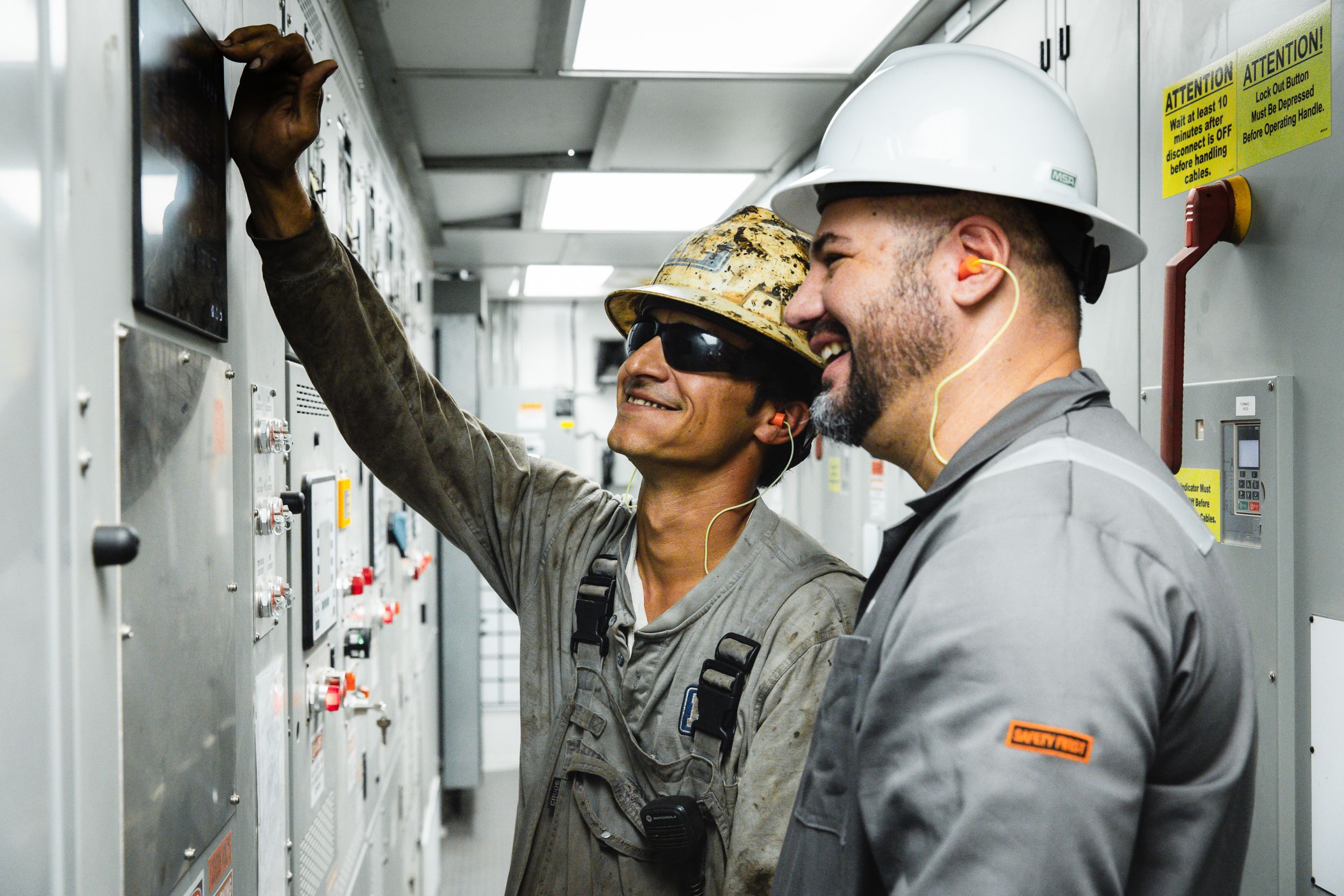 Steven Youssef standing next to a coworker in front of a control panel