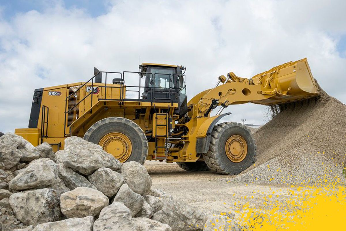 carregadeira de rodas grande despejando pedras na pilha