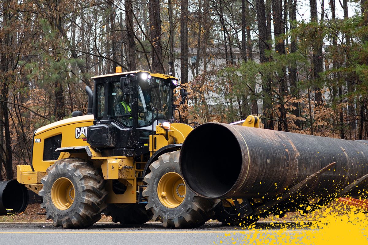 carregadeiras de rodas pequenas transportando tubos grandes