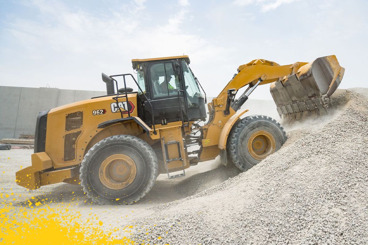 operador despejando pedra do balde em uma pilha grande