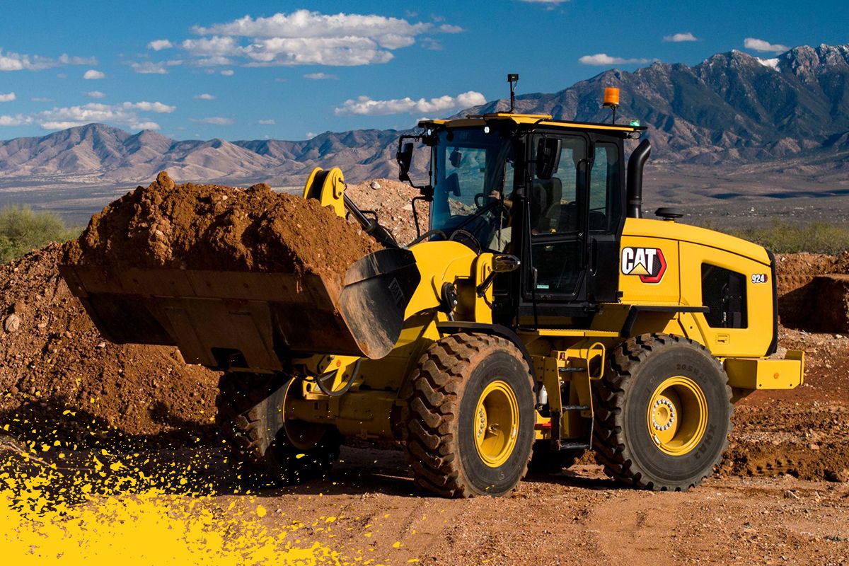 carregadeira de rodas pequena trabalhando no deserto com caçamba cheia