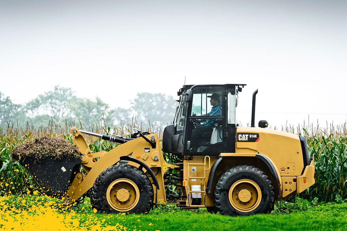 914K operando em campo de milho com caçamba cheia