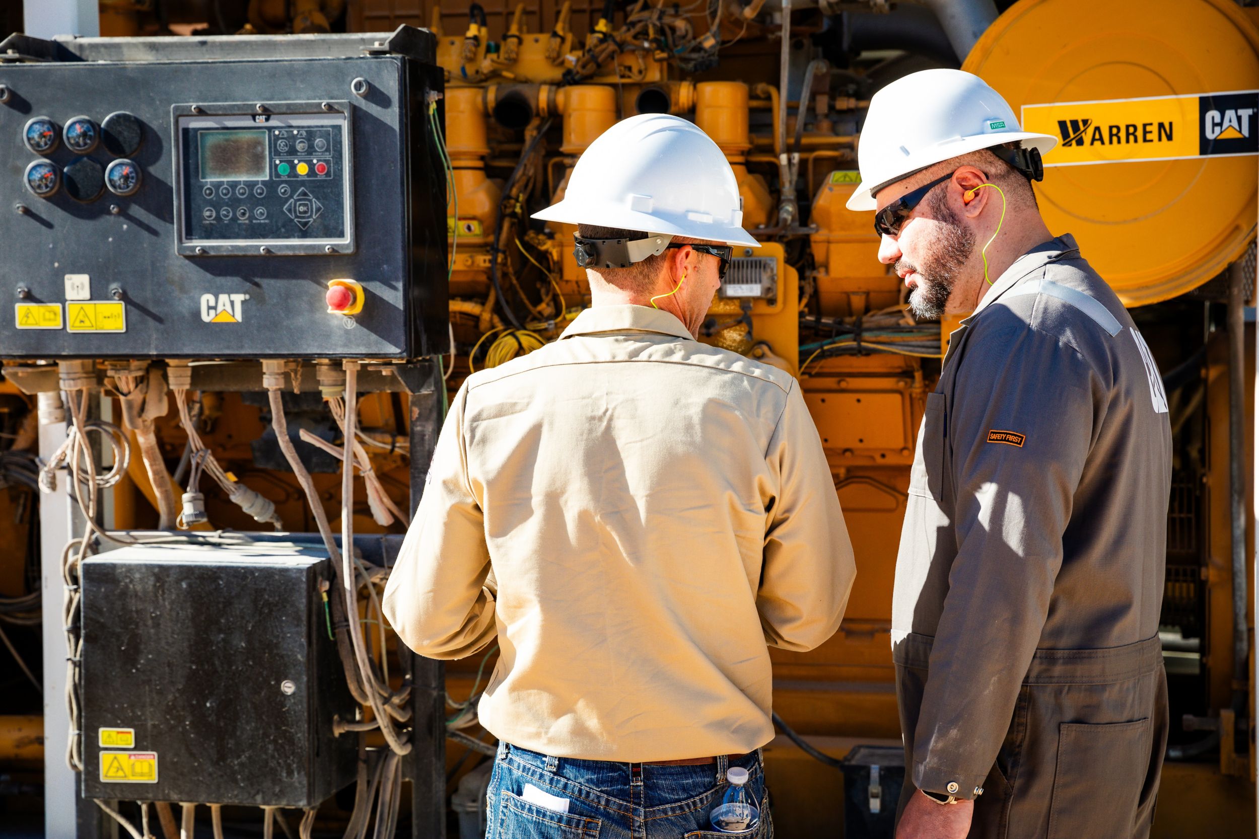 Cat Dynamic Gas Blending Service - Two men in front of the engine