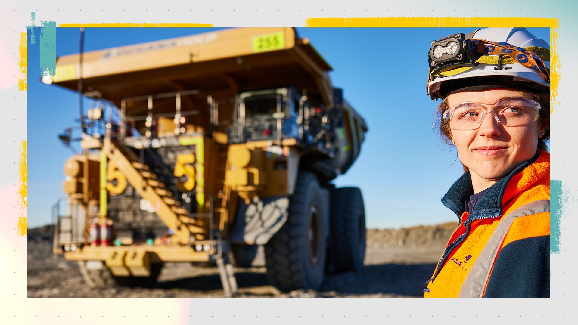 Woman smiling in front of a Cat Mining Truck