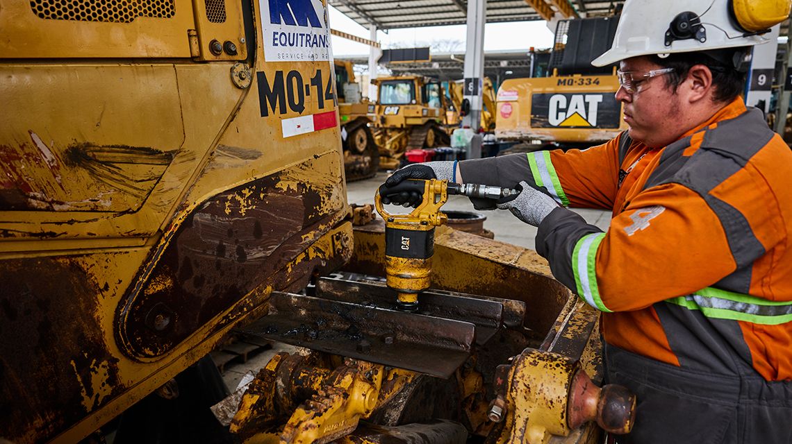 Man inspecting machine parts with a flashlight