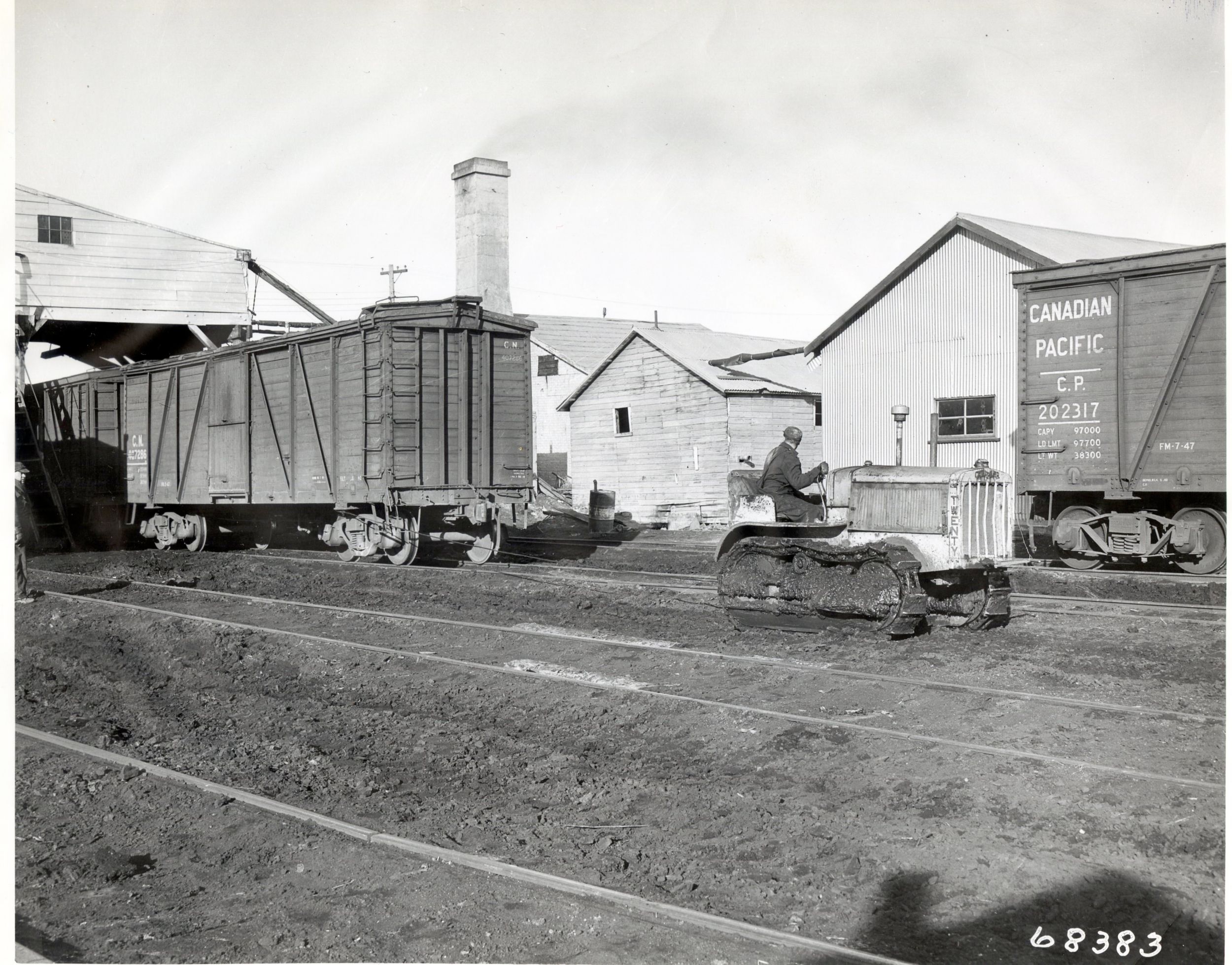 Caterpillar Model Twenty Track-Type Tractor pulling a train car, ca. 1928.