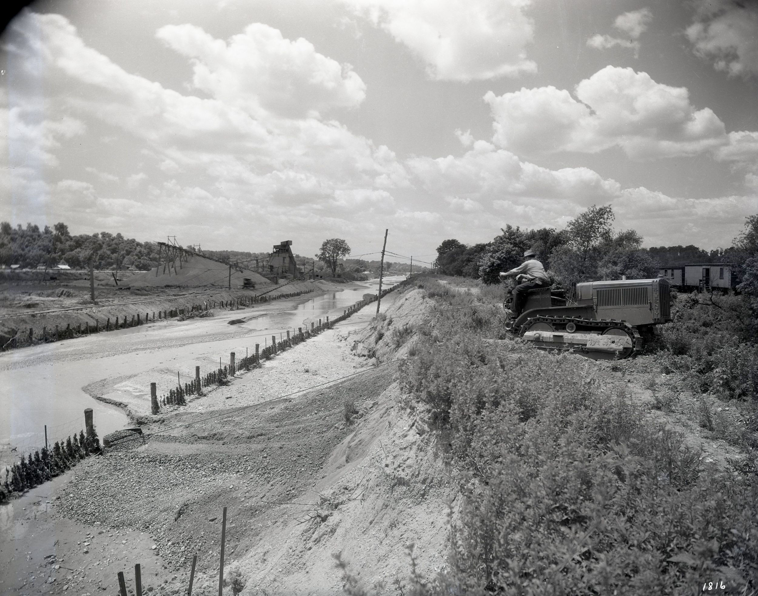 Caterpillar Model Twenty Track-Type Tractor with a dragline repairing the bank of the new drainage channel of Farm Creek in East Peoria, Illinois, 1930.