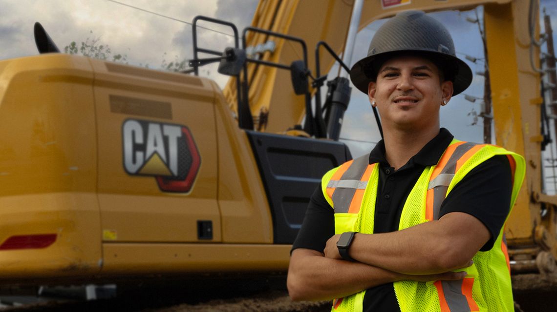 worker standing in front of a Cat machine