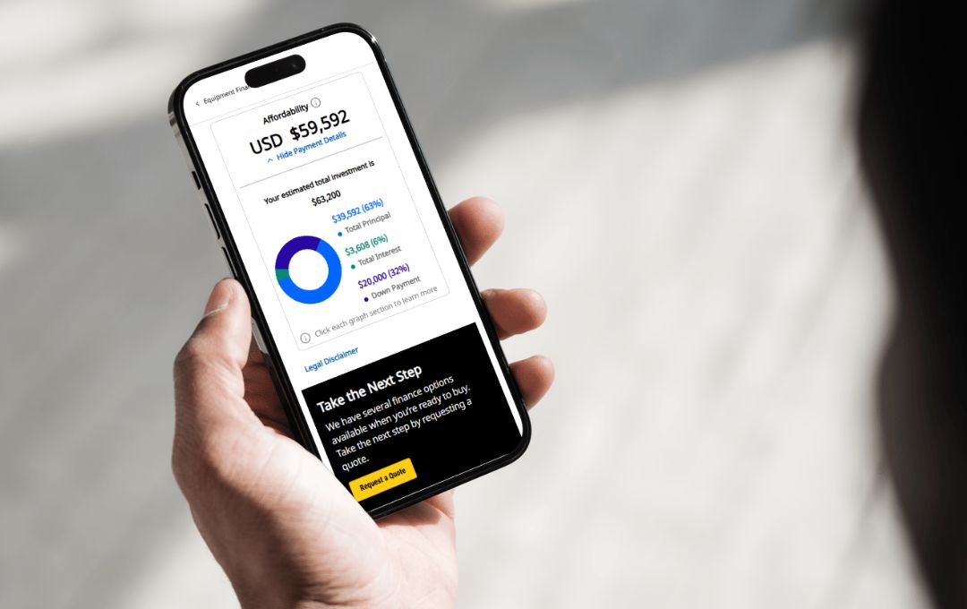 two equipment operators looking at a laptop