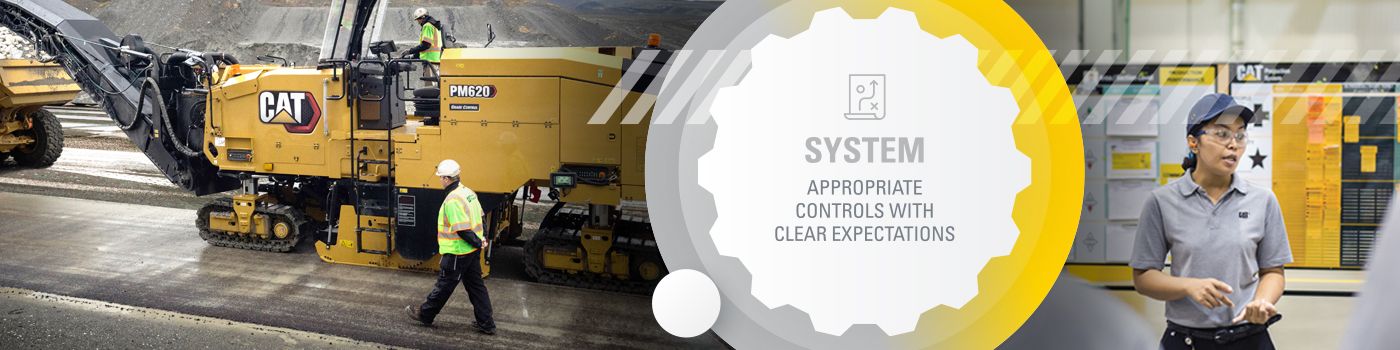 Two men talking in front of a Cat machine