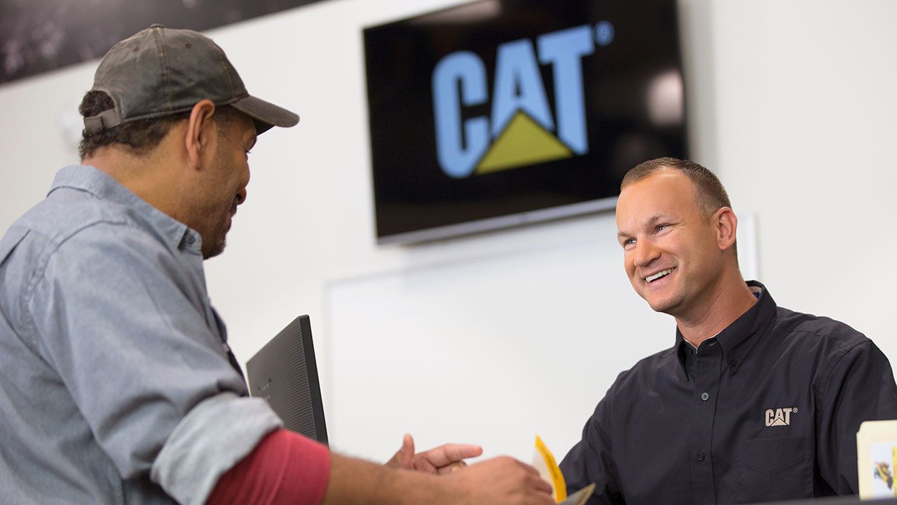 Cat dealer talking with customer