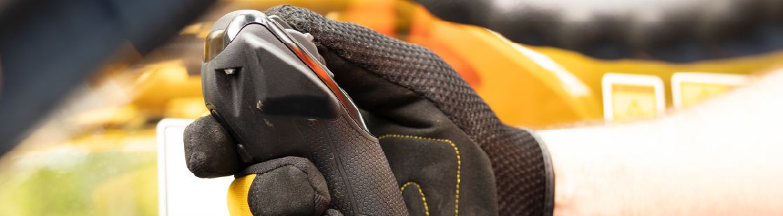 hand grasping controls of machine