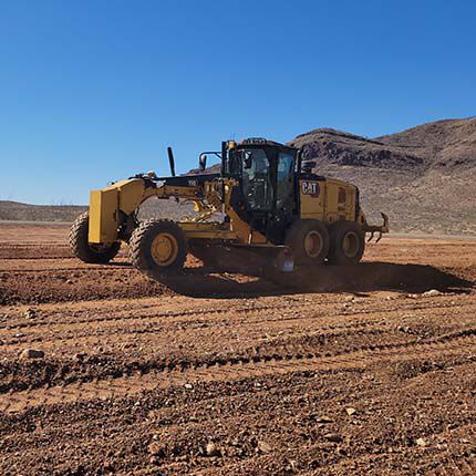 Motor grader paving dirt ground
