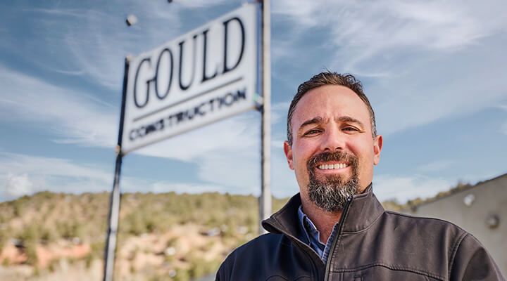 Mark Gould Jr. in front of a Gould Construction sign