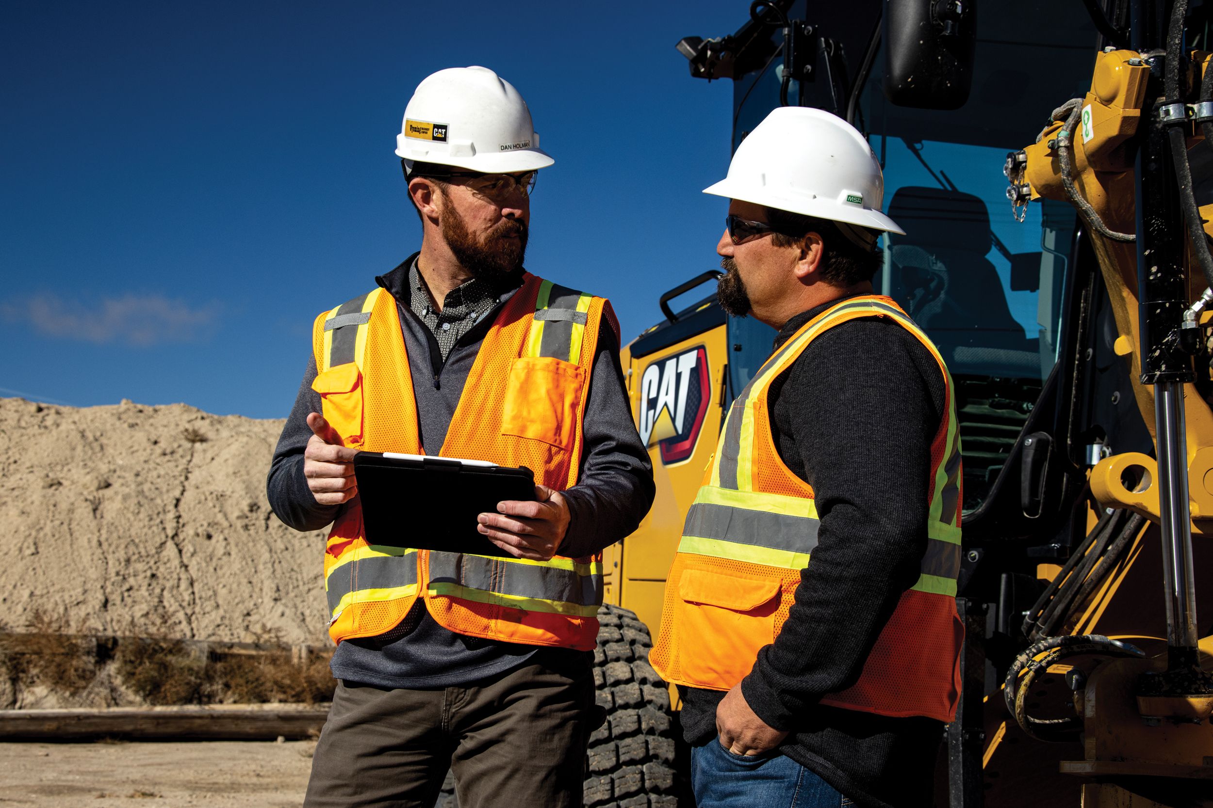 Two men talking in front of machine
