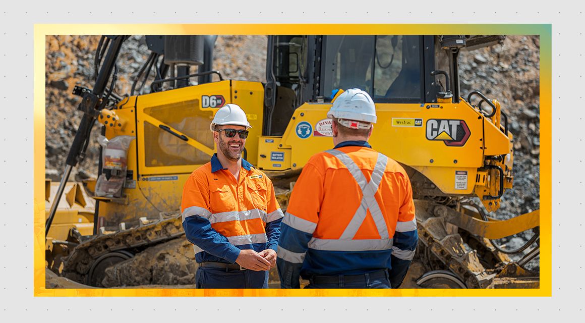 Two men talking in front of a D6 dozer