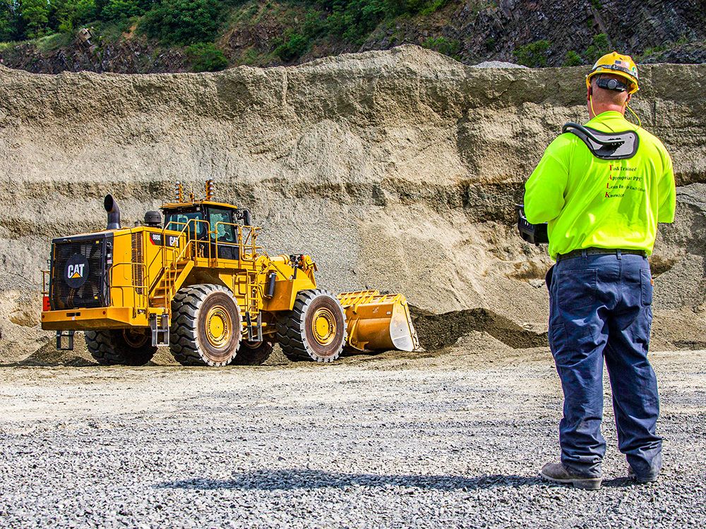 operator using remote control to operate a wheel loader