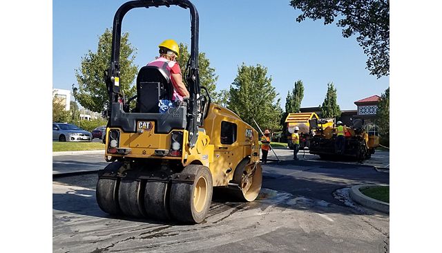 Cat CC2.7 tandem vibratory roller compacting asphalt in a parking lot.