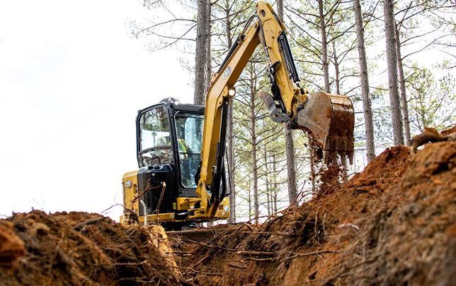 Mini escavadora usando um acessório de balde para pegar terra