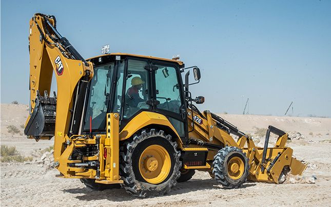 Retroexcavadora 426 limpiando escombros en el campo