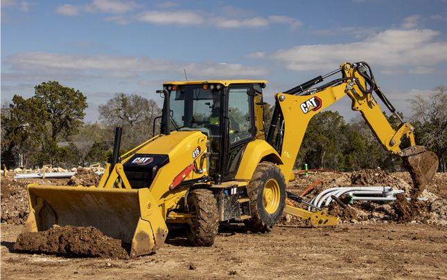 Cargadora retroexcavadora 416 limpiando tierra y escombros en el campo
