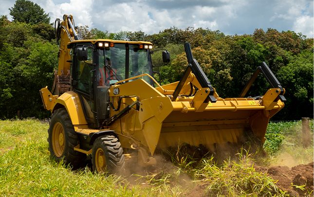 Excavadora de orugas 420 descargando tierra en el campo