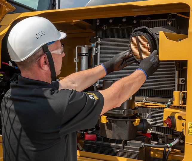 Homem inspecionando filtros no 318 GC