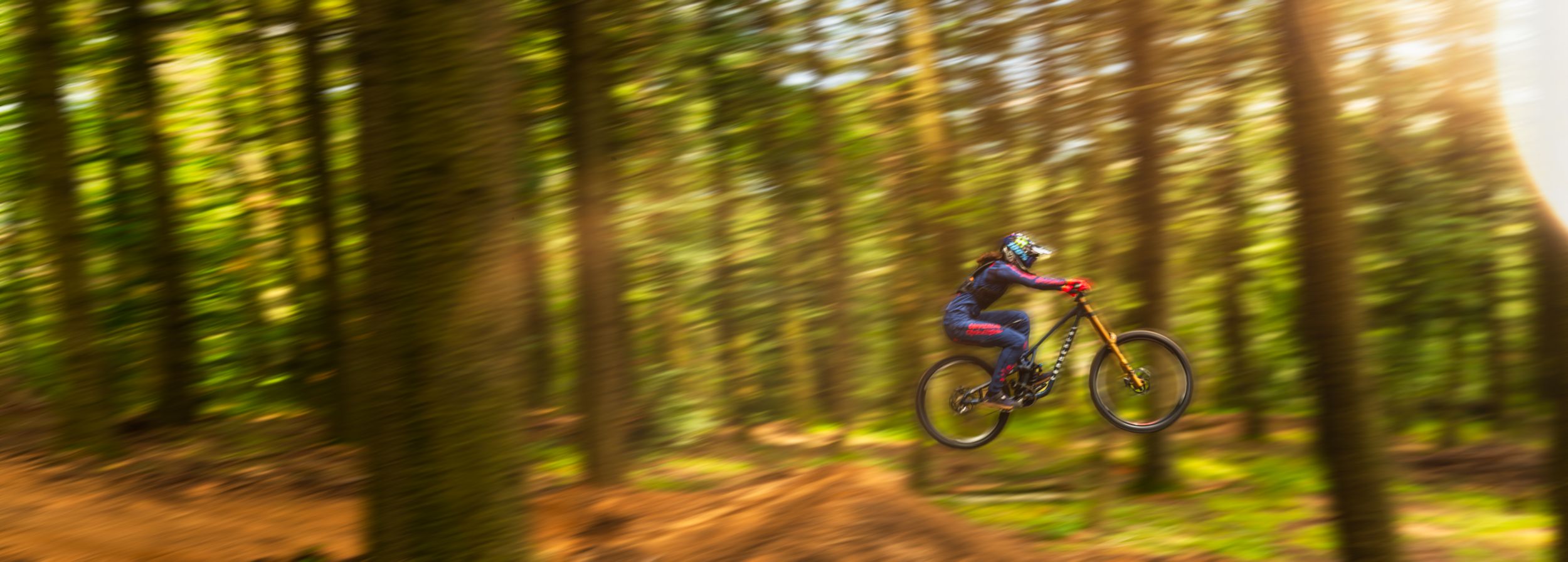 Baptiste Pierron beim Mountainbiking vor Cat-Minibaggern