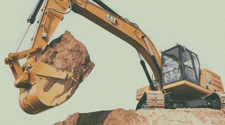 excavator on site digging up some dirt