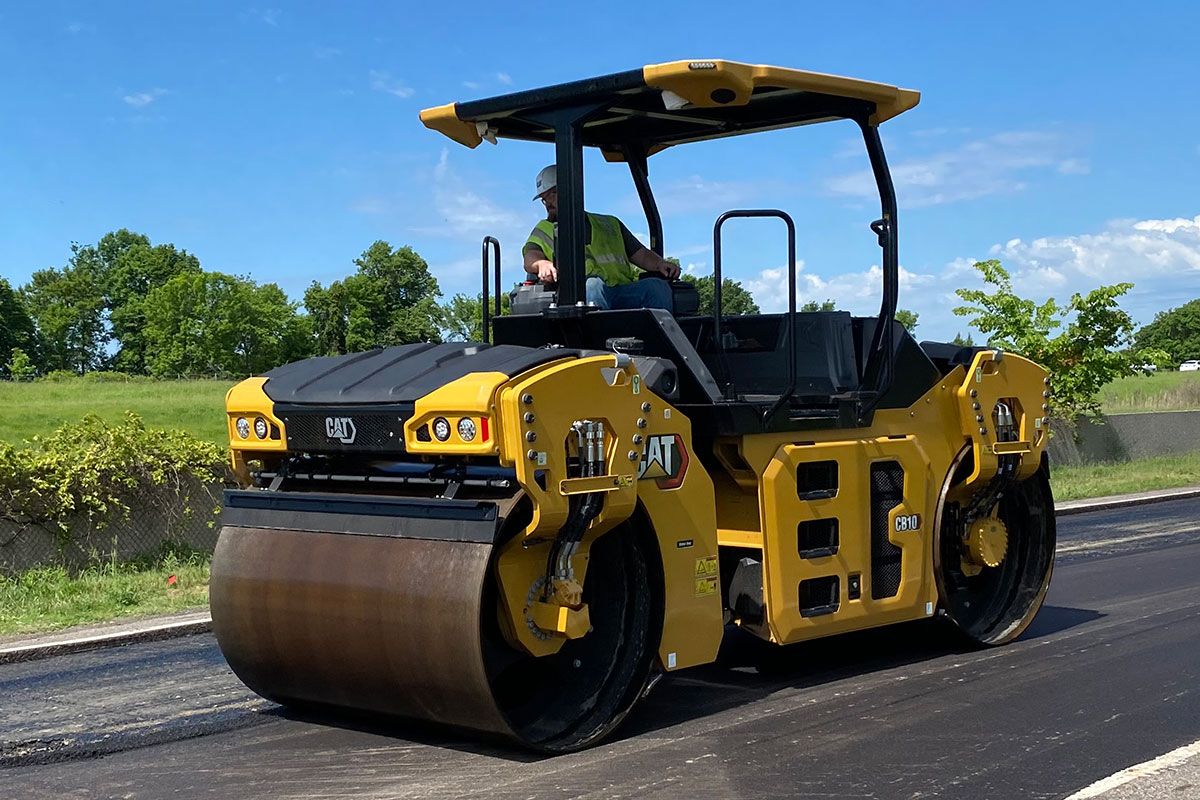 Un compactador de asfalto pasando sobre una carretera recién pavimentada